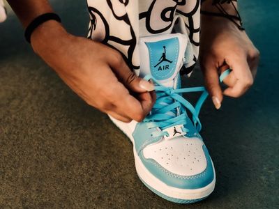 Person hands tying laces of athletic shoes.